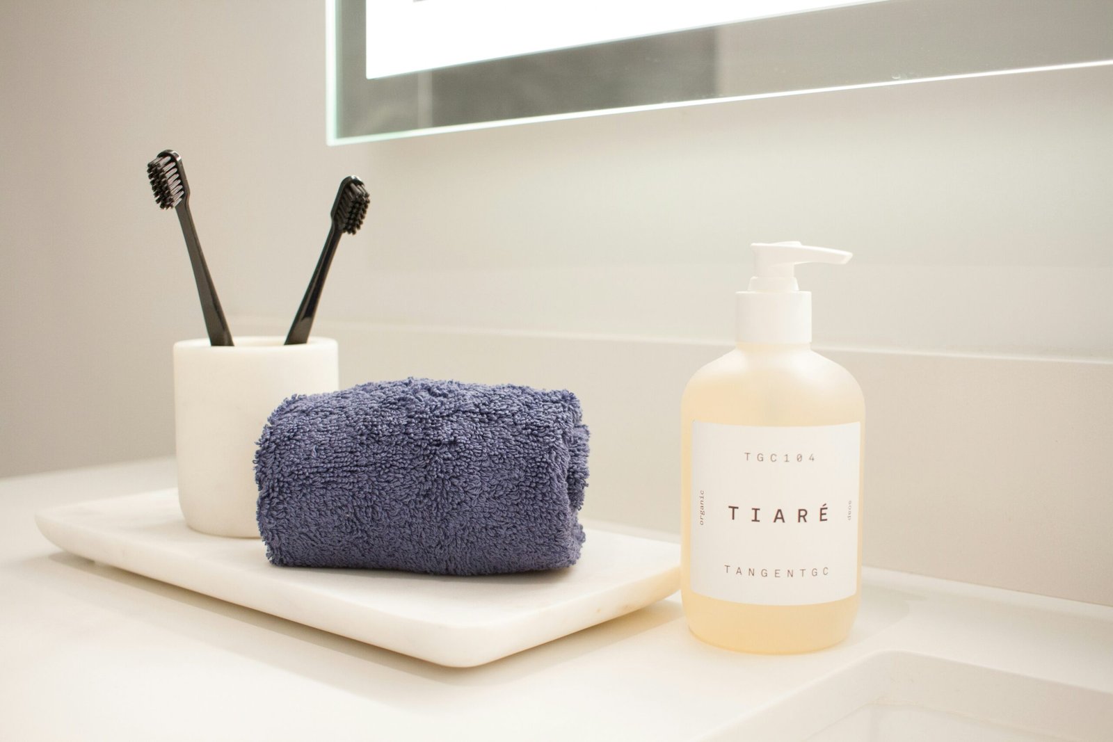 a bathroom counter with a soap, toothbrush, and soap dispenser